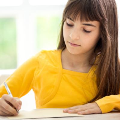 girl with yellow shirt writing